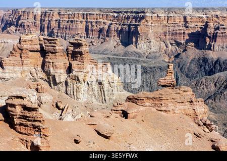 Antichi pilastri di arenaria e scogliere sedimentarie a strati che definiscono l'aspro paesaggio geologico della Valle dei Castelli nel Parco Nazionale di Charyn Kaz Foto Stock