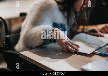 Studentessa che studia su una scrivania con notebook e penna, si concentra sulla presa di appunti Foto Stock