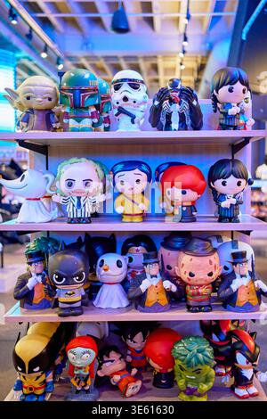 Collezione di figure in vinile per colture pop sugli scaffali di un negozio. Include personaggi di Star Wars, DC Comics e film horror. Esposizione al dettaglio. Foto Stock