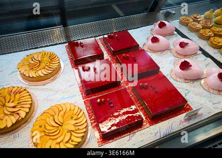 Pasticceria gourmet al Bottega Louie di Los Angeles. Torte rosse smaltate, mousse a forma di cuore e crostate di frutta in una moderna vetrina di vetro da forno. Foto Stock