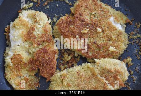 Filetti di pollo in crosta di quinoa disposti su un piatto, vista dall'alto, con consistenza dorata croccante e ingredienti sani. Ideale per concetti di sano Foto Stock