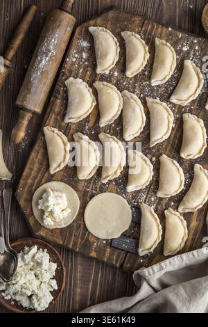 Cibo, gnocchi di formaggio cottage crudi fatti in casa su sfondo di legno, vista dall'alto Foto Stock