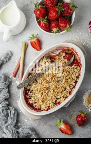 Cibo, rabarbaro e fragola, torta di avena sbriciolata in piatto da forno, vista dall'alto Foto Stock