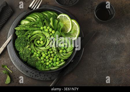 Cibo, insalata di verdure verdi fresche, piatto vegano per pranzo disintossicante. Sfondo scuro. vista dall'alto Foto Stock