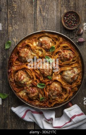 Cibo, polpette nei nidi di pasta con salsa di pomodoro, vista dall'alto, sfondo in legno Foto Stock