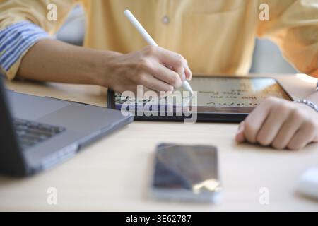 Web designer maschile che disegna con un tablet grafico al tavolo in ufficio, primo piano Foto Stock