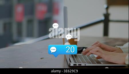 Digita le mani nel maglione color crema sul balcone utilizzando un laptop con tazze, il badge della chat 20, spazio per copiare Foto Stock