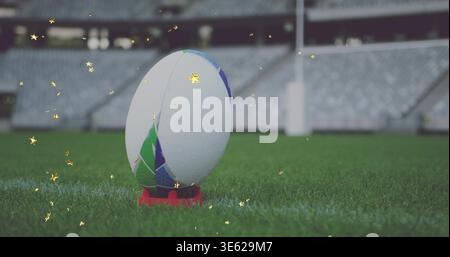 Fuoco ravvicinato della palla da rugby mostrando rugiada su una maglietta da calcio rossa in campo, scintillio d'oro Foto Stock