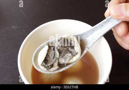 Zuppa di sesamo nero di influenza cinese in zuppa calda di zenzero dolcificata chiamata Bua Loy Nam King Foto Stock