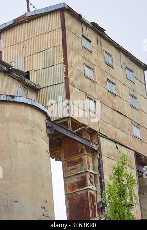 Un edificio industriale a più piani costruito con pannelli in metallo ondulato in varie tonalità di beige, marrone e grigio. La struttura Foto Stock