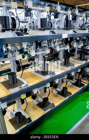 Molte stampanti 3D stampano oggetti. Stampanti 3D che creano forme da plastica fusa che fuoriesce dall'estrusore. Primo piano della stampante 3D. Utilizzo della stampante 3D in un oggetto di stampa di processo da plastica nera fusa Foto Stock