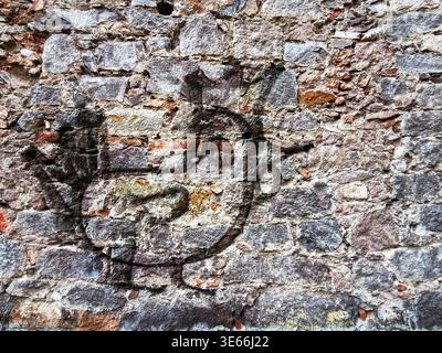 Semplice illustrazione disegnata a mano di una figura di pollo scolpita o dipinta su una rustica struttura di pietra intemprata Foto Stock
