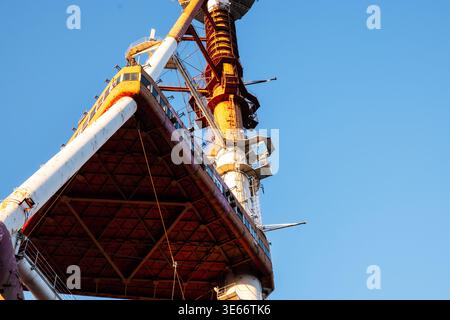 Vista ad angolo basso dei montanti di supporto in acciaio bianco e rosso intemprato della torre televisiva Tbilisi nel Parco Mtatsminda Foto Stock