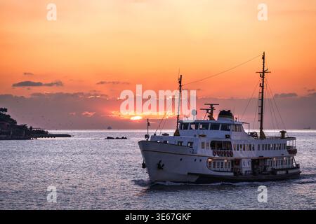 Un traghetto vecchio stile naviga sul mare al crepuscolo Foto Stock