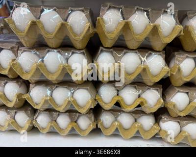 Cartoni per uova impilati in modo ordinato, adatti per il tema del mercato o per lo sfondo. Foto mobile Foto Stock