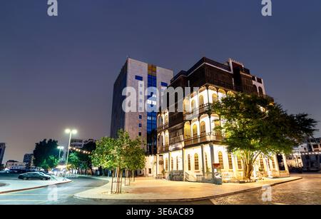 Una tradizionale casa Hijazi splendidamente illuminata nello storico quartiere al Balad di Jeddah, Arabia Saudita di notte Foto Stock