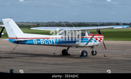 Cambridge, Regno Unito - 7 aprile 24: Aeromobili leggeri parcheggiati sul piazzale con pareggi e campo di aviazione in erba a IWM Duxford, Cambridgeshire, Inghilterra. Foto Stock