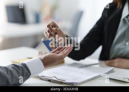 Immobili o intermediari residenziali o agenti che mostrano la chiave della casa Foto Stock