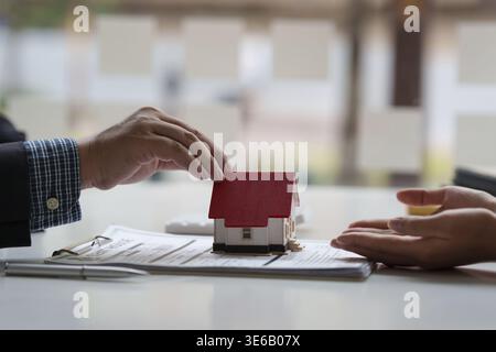 Chiudere un uomo d'affari o un agente che dà casa dopo aver firmato un accordo per comprare casa. Direttore di banca e concetto immobiliare Foto Stock