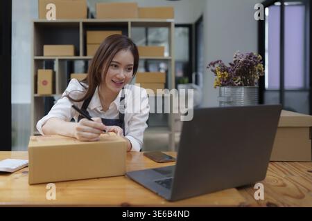 Attraente imprenditore asiatico donna di affari che controlla l'ordine Foto Stock