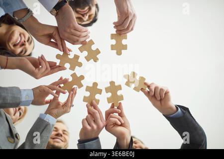 Puzzle abbinati, colleghi diversi che tengono pezzi di legno, trovano idee, cercano affari Foto Stock