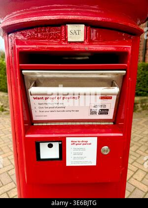 Un pacco e una cassetta postale della Royal mail Foto Stock