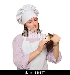 Chef donna in uniforme che guarda nel portafoglio vuoto. Cuoco triste che tiene aperte le banconote senza soldi all'interno. Crisi finanziaria nell'industria della ristorazione e nell'unem Foto Stock