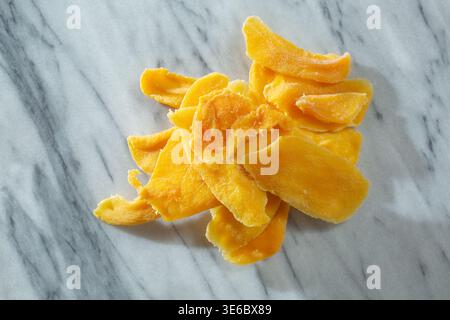 Vista dall'alto verso il basso di una pila di fette di mango essiccate. Foto Stock