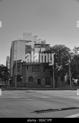 Edificio ad angolo con alberi e appartamenti più alti dietro a Santiago, Cile. Foto Stock