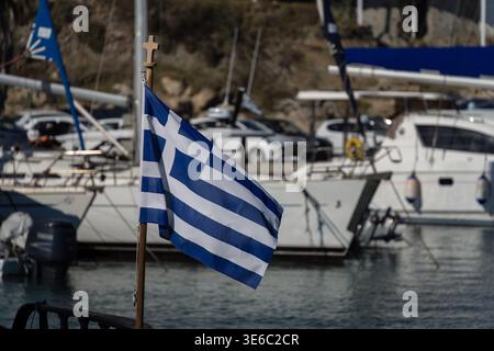 Bandiera greca su un palo con una croce in cima in un porto di Santorini, Grecia Foto Stock