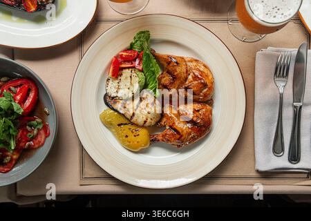 Pollo alla griglia con verdure e salsa sul piatto Foto Stock