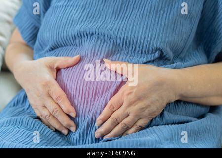 Dolore addominale nella donna anziana anziana anziana anziana anziana che invecchia con mal di stomaco malattia da cancro allo stomaco, sindrome dell'intestino irritabile, indigestione, diarrea, gastr Foto Stock