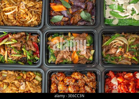 Una vista dall'alto verso il basso di diversi piatti fast food cinesi, come sfondo. Foto Stock