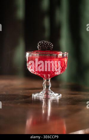 Cocktail rosso con mora in vetro vintage Foto Stock