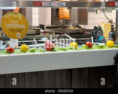 Cracovia, Polonia - 1° dicembre 2025: Vista di un vivace fast food, che presenta un bar di insalate con verdure fresche come lattuga, limoni, peperoni e. Foto Stock