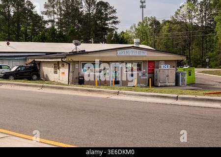 Raleigh, North Carolina: Minimarket all'esterno di Raleigh, North Carolina, con parcheggio a lato della strada, macchina per il ghiaccio e negozi di tutti i giorni. Foto Stock