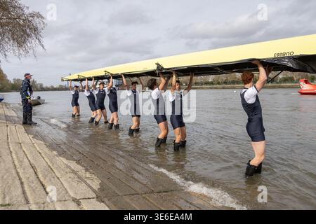 Squadra di canottaggio maschile dell'Università di Oxford che trasporta la propria barca sul Tamigi a Putney in vista della gara di barche del 2026 Foto Stock