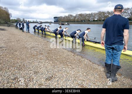 Gare di barche dell'Università di Oxford donne che vogano posizionando una barca teschio nel fiume Tamigi a Putney prima della gara di barche Foto Stock