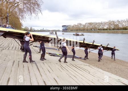 Le donne che trasportano la barca teschio al fiume guidate dal presidente Heidi Long con Annie Anezakis alle spalle Foto Stock