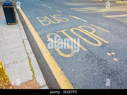 La segnaletica stradale della fermata dell'autobus è stata dipinta sull'asfalto della strada di Londra, sulla segnaletica dei trasporti urbani, sui dettagli del traffico cittadino e sul concetto di trasporto pubblico nel Regno Unito Foto Stock