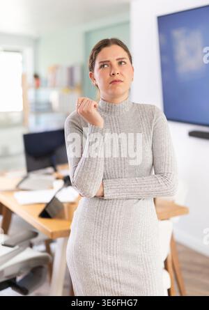 Giovane donna triste mentre lavora in ufficio Foto Stock