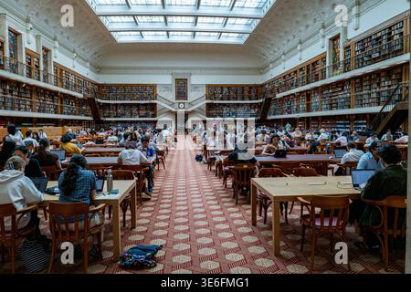 Interno della storica Mitchell Reading Room presso la State Library del New South Wales con i clienti che studiano su lunghi tavoli di legno. Foto Stock