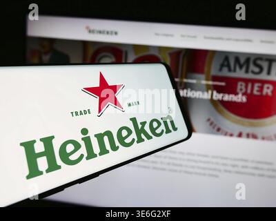 Stoccarda, Germania - 08-12-2024: Cellulare con logo della società olandese Heineken N.V. davanti al sito web aziendale. Concentrati sul centro del telefono Foto Stock