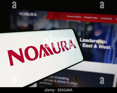 Stoccarda, Germania - 08-12-2024: Smartphone con logo della società giapponese di servizi finanziari Nomura Holdings Inc. Davanti al sito Web aziendale. Concentrati Foto Stock