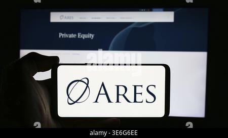 Stoccarda, Germania - 08-12-2024: Persona che detiene il cellulare con il logo della società di investimento statunitense Ares Management Corporation davanti alla pagina web aziendale. Foto Stock
