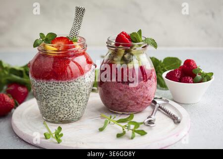 Budini di semi di chia con frutti di bosco e frutta per colazione Foto Stock