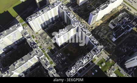 Alti edifici residenziali con complessi in costruzione. Movimento. Vista dall'alto del contrasto visibile dell'area edificata e popolata nelle vicinanze Foto Stock