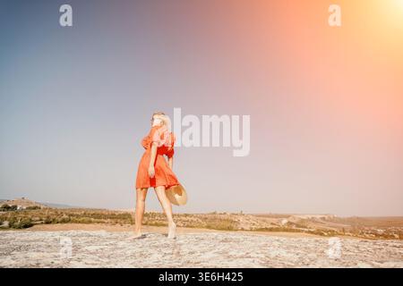 Donna in abito rosso che cammina su un affioramento roccioso Foto Stock