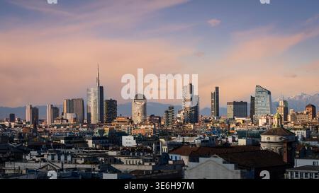 Vista dello skyline di Milano al tramonto, dei tetti e dei grattacieli della città. Sullo sfondo zona CityLife con i tre grattacieli della torre, Milano, Lombar Foto Stock
