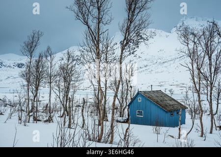 Cabina in legno nel paesaggio innevato, Kattfjordvatnet, Troms, Norvegia Foto Stock